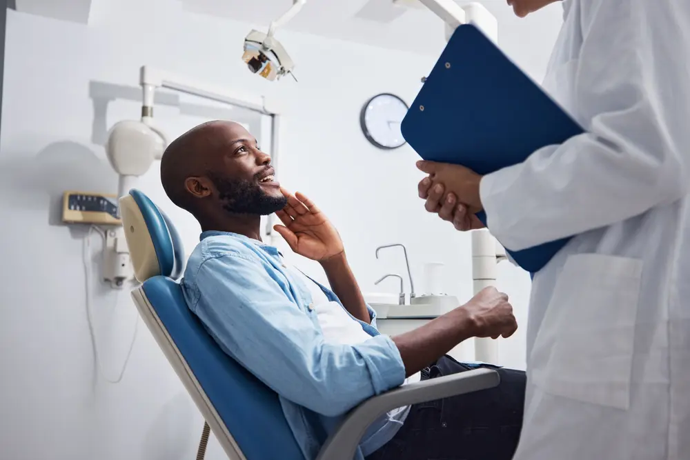 Dentist holding a clipboard near patient