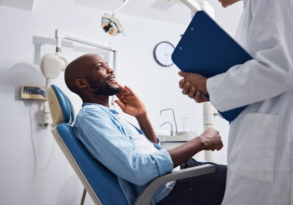 Dentist holding a clipboard near patient